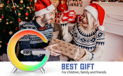 The image shows a festive scene with two people wearing Santa hats, and a circular device that functions as an alarm clock and smart lamp with wireless charging, being promoted as the best gift for children, family, and friends.
