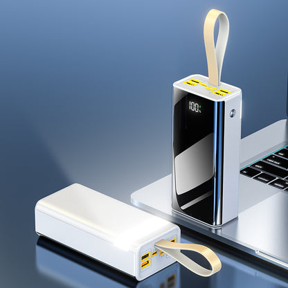 The image shows a portable power bank that is white on one side with a single port bordered by a yellow frame, and black on the other side with a digital display showing 100 percent charge and multiple ports bordered by yellow frames.