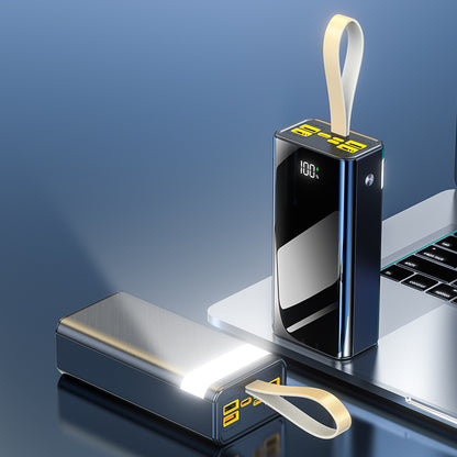 The image shows a portable power bank that is black on one side with a single port bordered by a yellow frame, and black on the other side with a digital display showing 100 percent charge and multiple ports bordered by yellow frames.