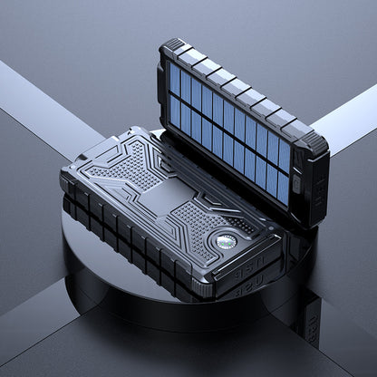 The image shows a black portable solar power bank with a solar panel on the lid. It has a sturdy black and blue design with multiple charging ports and an on/off switch on the main unit.