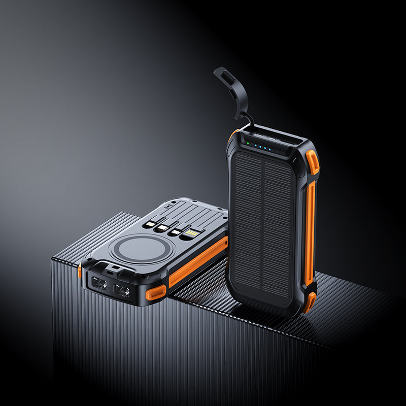 The picture shows two portable power banks with orange accents; one has a wireless charging area, multiple ports, and a solar panel, while the other features a similar design with a handle.
