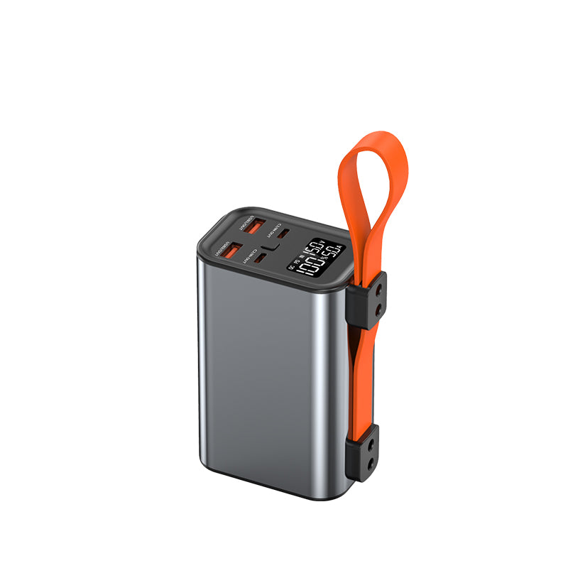 The picture shows a portable power bank with a metallic silver body, an orange strap, multiple charging ports, and a digital display showing "100:50".
