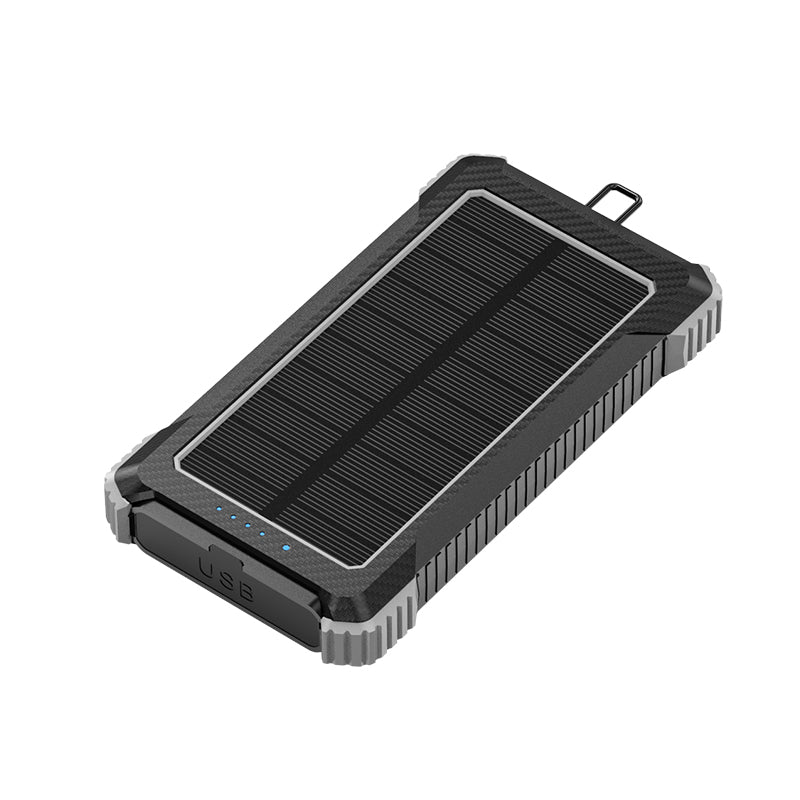 The picture shows a portable power bank with a solar panel on the top surface, featuring a rugged design with silver and black colors, and having a USB port on the side.
