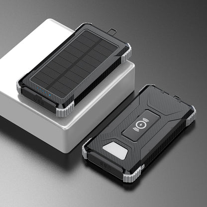 Pictured are two portable silver power banks with solar panels on top, one with a USB port indicated by a blue light, and the other with a wireless charging symbol.
